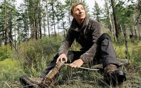 Dr. Nicole Apelian practicing wilderness skills in a forest